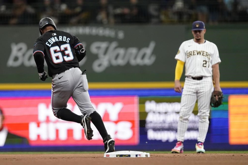 Miami Marlins' Xavier Edwards (63) rounds the bases in front of Milwaukee Brewers' Willy Adames, right, after hitting a solo home run during the first inning of a baseball game Sunday, July 28, 2024, in Milwaukee. (AP Photo/Aaron Gash)