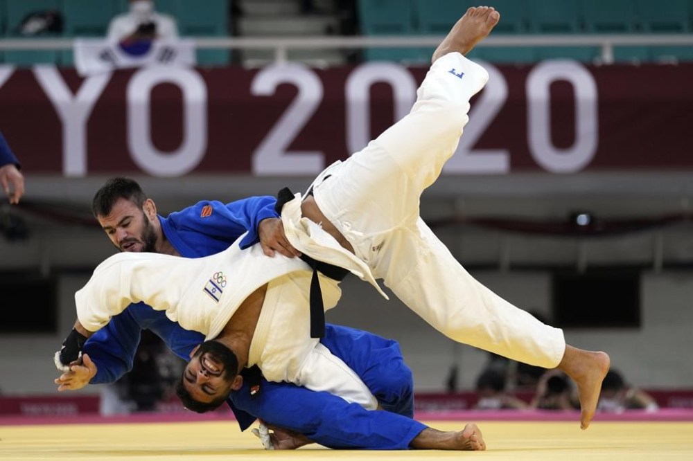 FILE - Victor Sterpu of Moldova, background and Tohar Butbul of Israel compete during their men's -73kg round of 16 judo match at the 2020 Summer Olympics in Tokyo, Japan, Monday, July 26, 2021. (AP Photo/Vincent Thian, FIle)