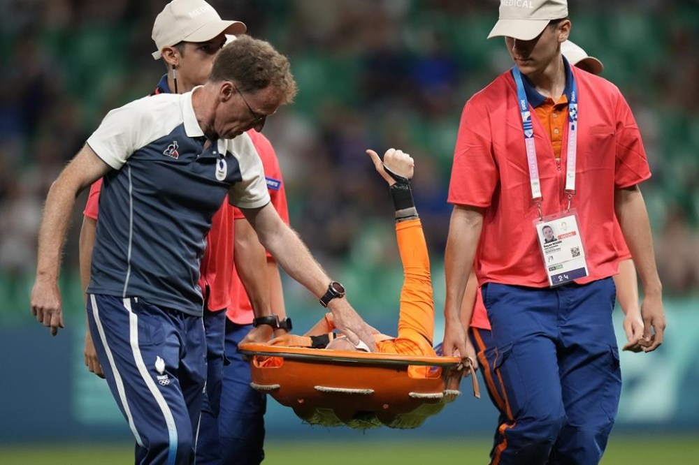 France's goalkeeper Pauline Peyraud-Magnin gives the thumb-up as she is carried off the pitch on a stretcher after getting injured during the women's Group A soccer match between Canada and France at Geoffroy-Guichard stadium during the 2024 Summer Olympics, Sunday, July 28, 2024, in Saint-Etienne, France. (AP Photo/Silvia Izquierdo)