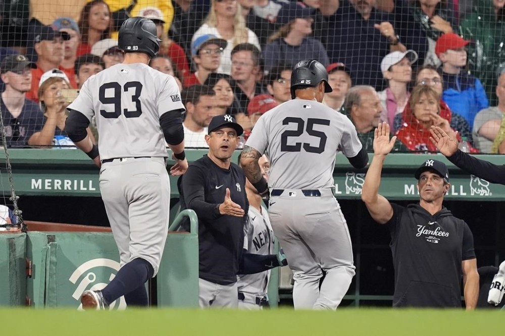 New York Yankees' Ben Rice (93) and Gleyber Torres (25) celebrate after scoring on a ground rule double by Oswaldo Cabrera during the eighth inning of a baseball game against the Boston Red Sox, Sunday, July 28, 2024, in Boston. (AP Photo/Michael Dwyer)
