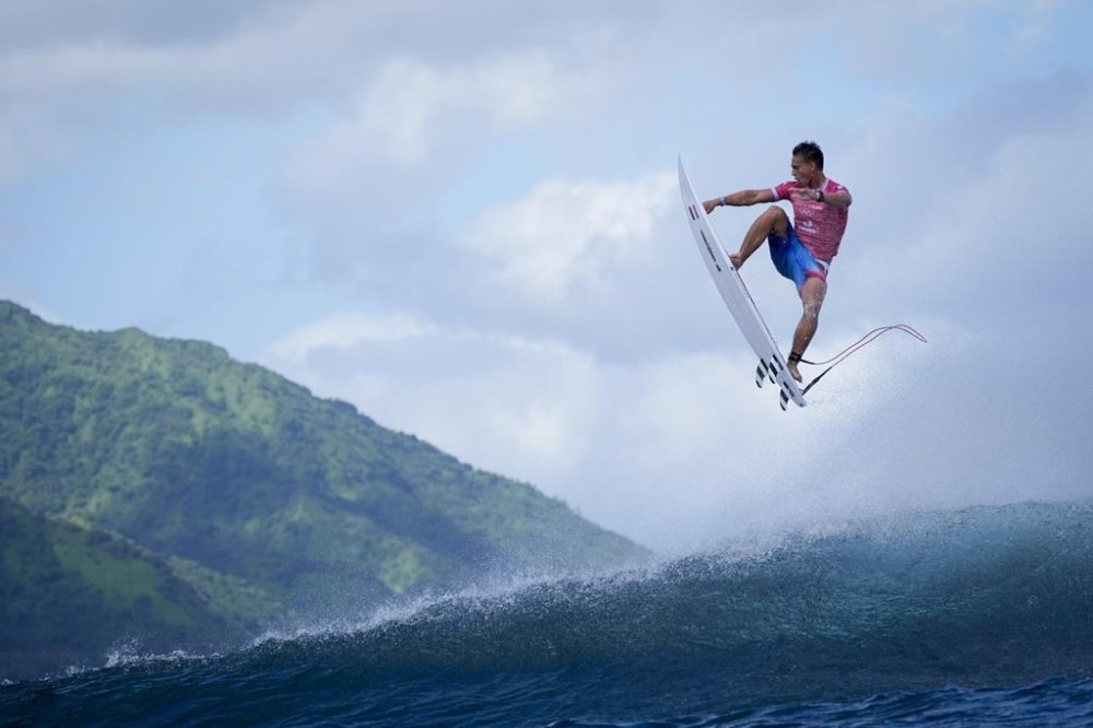 Kauli Vaast, of France, leaps over a wave during the second round of the 2024 Summer Olympics surfing competition Sunday, July 28, 2024, in Teahupo'o, Tahiti. (AP Photo/Gregory Bull)