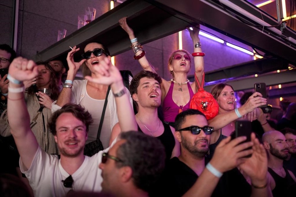 People dance as French musician Marc Cerrone performs during the DiscOlympics at Wanderlust night club at the 2024 Summer Olympics, Monday, July 29, 2024, in Paris, France. (AP Photo/Natacha Pisarenko)