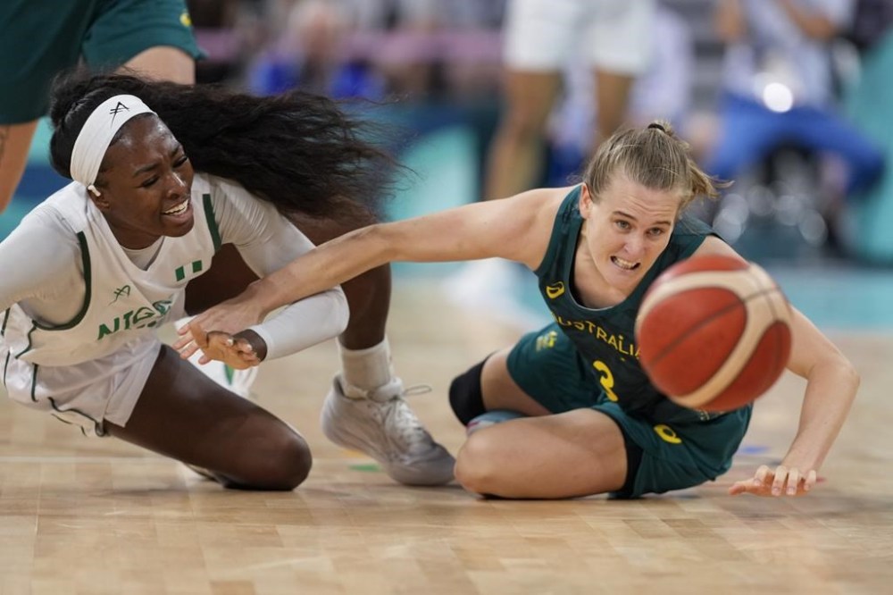 Nicole Enaosi, of Nigeria, and Kirsty Wallace, of Australia, chase a loose ball in a women's basketball game at the 2024 Summer Olympics, Monday, July 29, 2024, in Villeneuve-d'Ascq, France. (AP Photo/Mark J. Terrill)