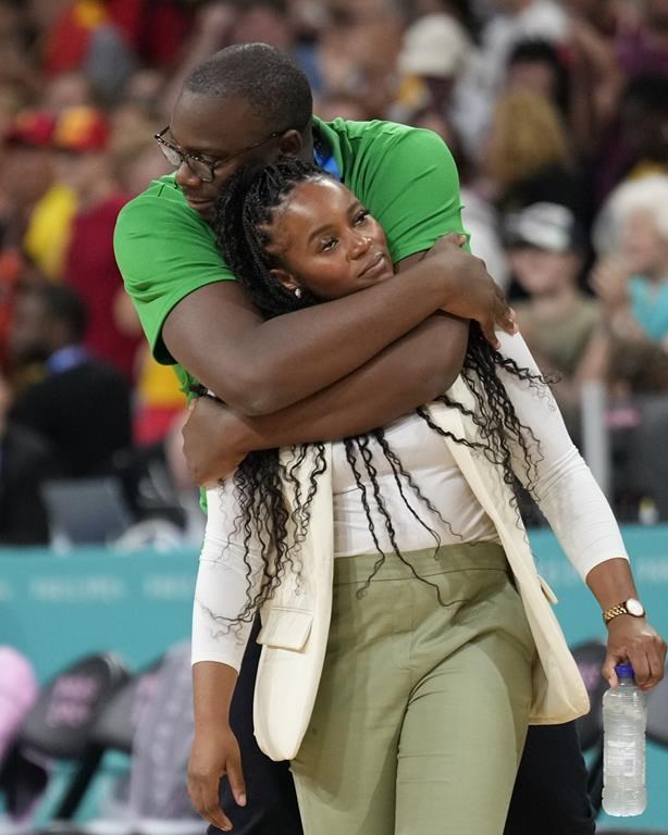 Nigeria head coach Rena Wakama is hugged from behind by coach Djoko Muganguziin after Nigeria defeated Australia in a women's basketball game at the 2024 Summer Olympics, Monday, July 29, 2024, in Villeneuve-d'Ascq, France. (AP Photo/Mark J. Terrill)
