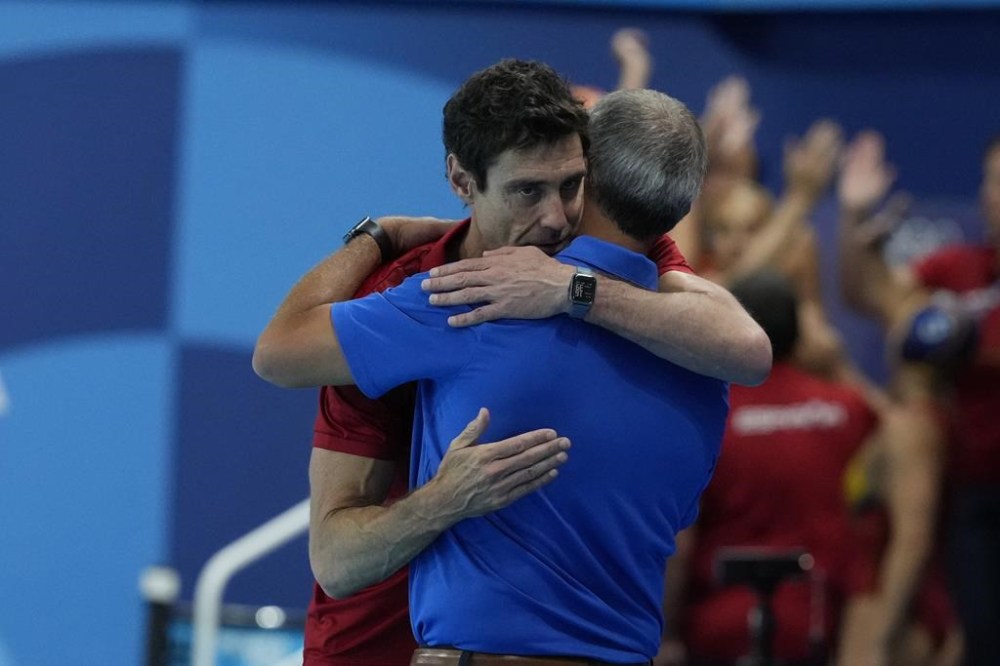 Spain's head coach Miguel Angel Oca Gaia and United States' head coach Adam Krikorian hug following their women's water polo Group B preliminary match between USA and Spain at the 2024 Summer Olympics, Monday, July 29, 2024, in Saint-Denis, France. (AP Photo/Luca Bruno)