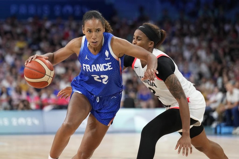 Marieme Badiane, of France, drives on Shay Colley, of Canada, in a women's basketball game at the 2024 Summer Olympics, Monday, July 29, 2024, in Villeneuve-d'Ascq, France. THE CANADIAN PRESS/AP-Mark J. Terrill