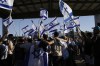 Protesters wave Israeli national flags in support of soldiers being questioned for detainee abuse, outside of the Sde Teiman military base, Monday, July 29, 2024. The Israeli military said Monday it was holding nine soldiers for questioning following allegations of 