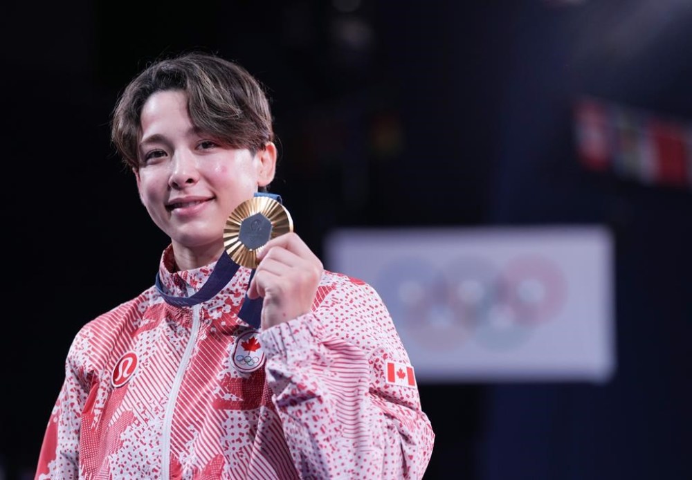 Canada's Christa Deguchi smiles as she shows her gold medal after her win in the women's under-57 kg judo at the 2024 Summer Olympics in Paris, France on Monday, July 29, 2024. THE CANADIAN PRESS/Christinne Muschi