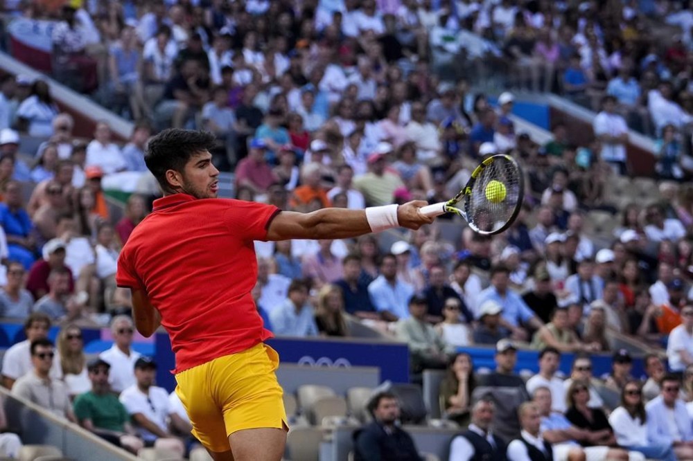 Carlos Alcaraz of Spain returns a forehand shot to Tallon Griekspoor of the Netherlands during their men's singles second round match, at the 2024 Summer Olympics, Monday, July 29, 2024, at the Roland Garros stadium in Paris, France. (AP Photo/Andy Wong)