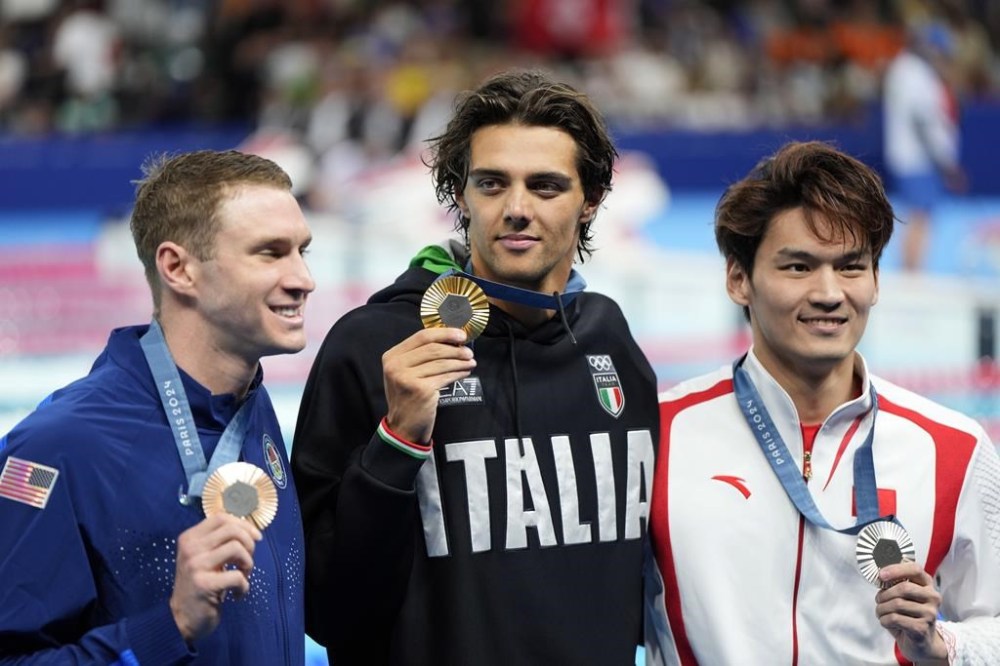 Gold medalist Thomas Ceccon, of Italy, poses with silver medalist Xu Jiayu, of China, left, and bronze medalist Ryan Murphy, of the United States, after the men's 100-meter backstroke final at the 2024 Summer Olympics, Monday, July 29, 2024, in Nanterre, France. (AP Photo/Martin Meissner)