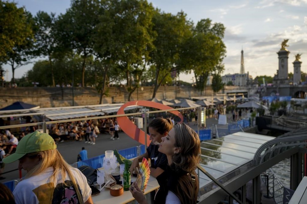 Marijo Raidy, right, attends the opening of Pride House, the safe space for the LGBT+ community of athletes, held on the Rosa Bonheur sur Seine boat during the 2024 Summer Olympics, Monday, July 29, 2024, in Paris, France. (AP Photo/Natacha Pisarenko)