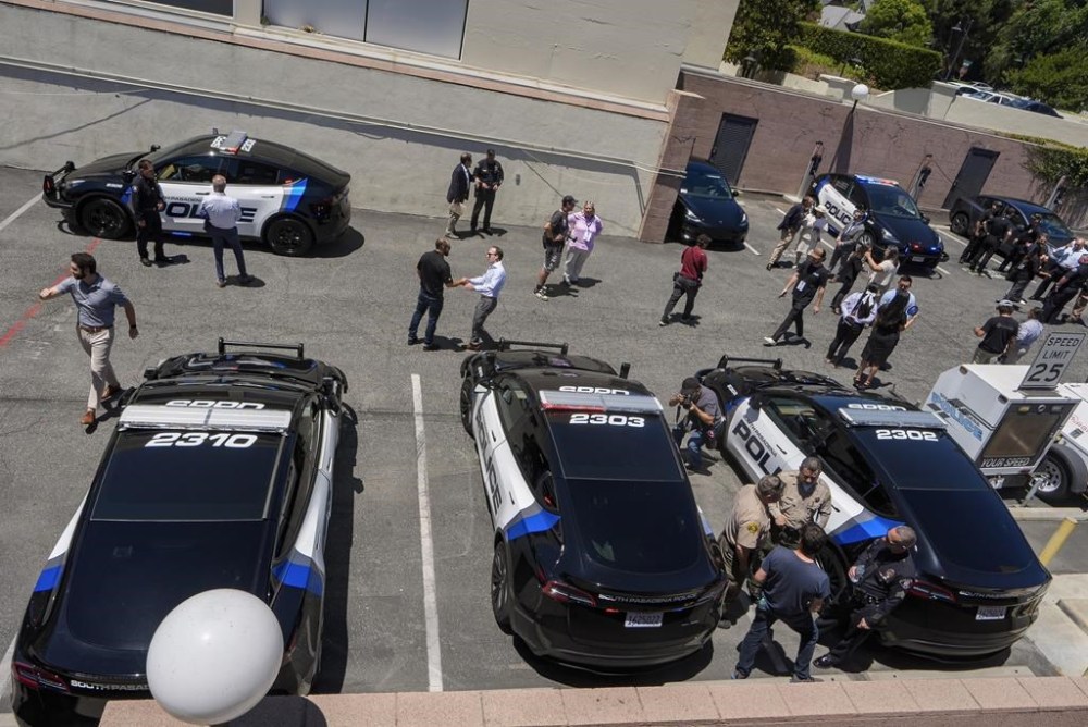 Visitors tour the back lot of the South Pasadena Police Department after the unveiling of its zero-emission police fleet of 20 Teslas Monday, July 29, 2024, in South Pasadena, Calif. (AP Photo/Damian Dovarganes)
