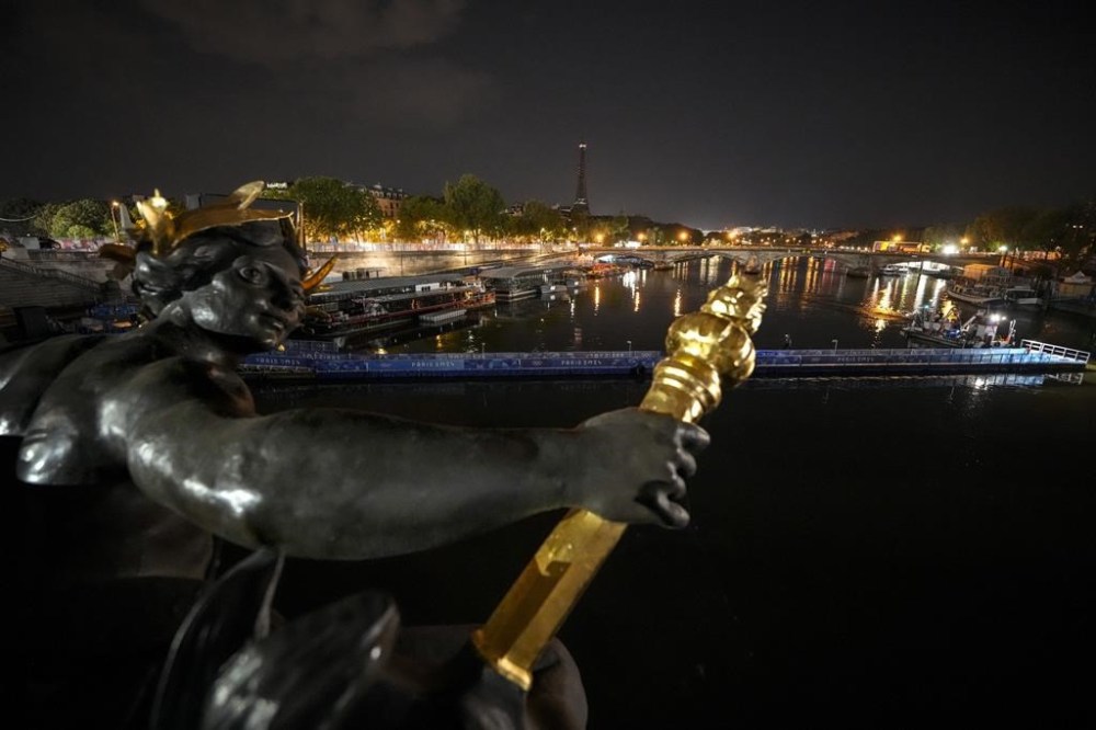 Technicians remove the pontoon for the start of the triathlon events after the event was postponed over concerns about water quality in Paris' Seine River, at the 2024 Summer Olympics, Tuesday, July 30, 2024, at the Pont Alexandre III bridge in Paris, France. (AP Photo/Vadim Ghirda)