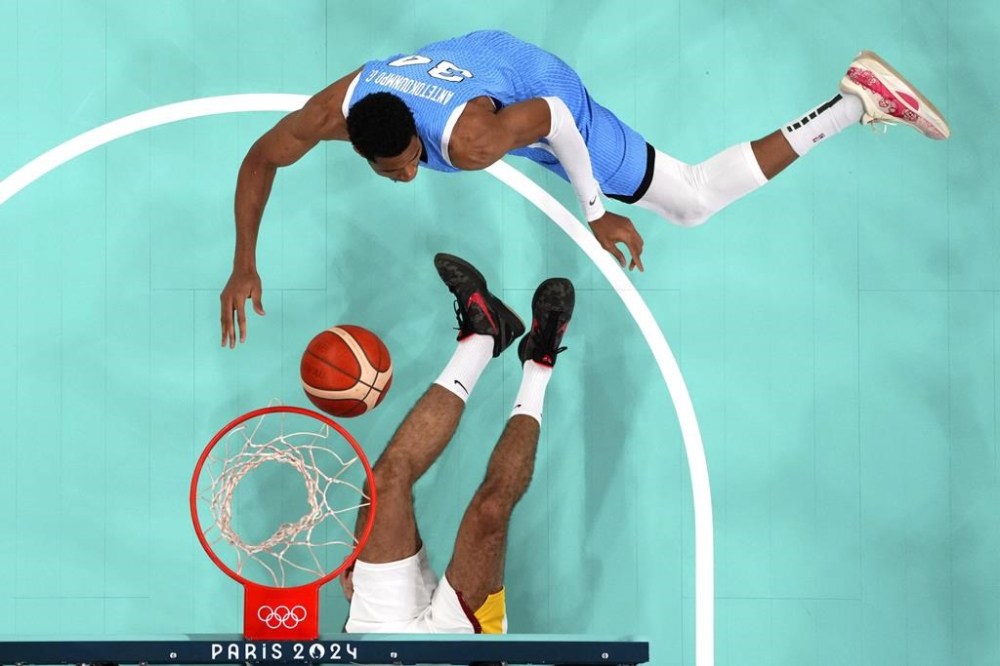 Giannis Antetokounmpo, top, of Greece, shoots as Santi Aldama, of Spain, falls during a men's basketball game at the 2024 Summer Olympics, Tuesday, July 30, 2024, in Villeneuve-d'Ascq, France. (Evelyn Hockstein/Pool Photo via AP)