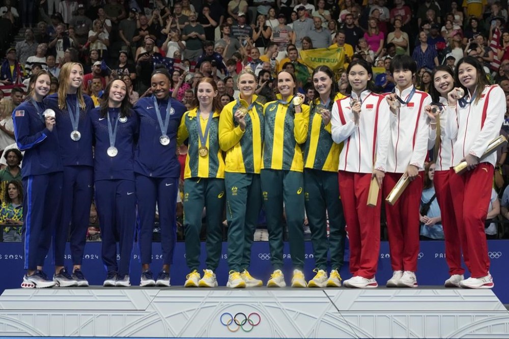 Gold medalists from Australia, middle, stand with silver medalists from the United States, left, and bronze medalists from China on the podium after the women's 4x100-meter freestyle relay at the 2024 Summer Olympics, Saturday, July 27, 2024, in Nanterre, France. (AP Photo/Matthias Schrader)