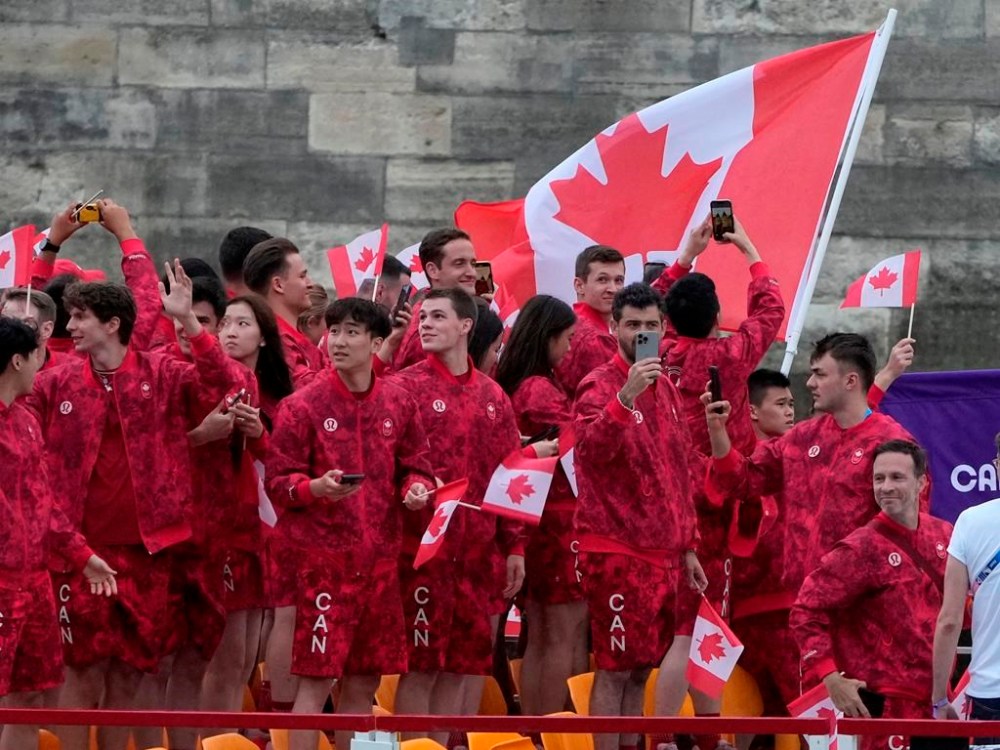 115 people are volunteering with Team Canada in Paris, greeting visitors to Canada Olympic House and supporting operations for the team and event. Canadian athletes wave from a boat on the Seine River during the opening ceremony for the 2024 Summer Olympics in Paris on Friday, July 26, 2024. THE CANADIAN PRESS/Adrian Wyld