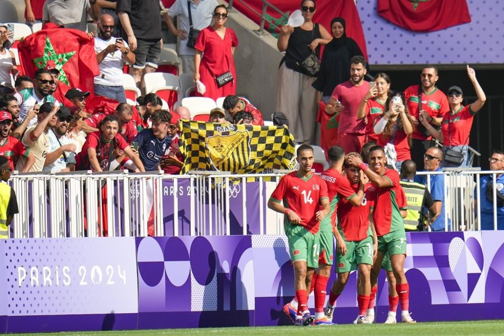 Morocco players celebrate their side's third goal by Abde Ezzalzouli (16) during a men's Group B soccer match between Morocco and Iraq at Nice Stadium at the 2024 Summer Olympics, Tuesday, July 30, 2024, in Nice, France. (AP Photo/Julio Cortez)