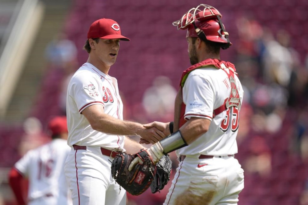 Cincinnati Reds' Lucas Sims, left, celebrates with Austin Wynns, right, after their victory over the Colorado Rockies in a baseball game, Thursday, July 11, 2024, in Cincinnati. (AP Photo/Jeff Dean)