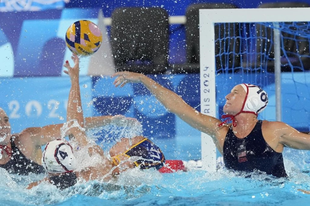 FILE - Spain's Maica Garcia Godoy, center bottom, and United States' Kaleigh Gilchrist battle for the ball during a women's water polo Group B preliminary match between USA and Spain at the 2024 Summer Olympics, Monday, July 29, 2024, in Saint-Denis, France. The most violent area of the pool during the Olympic water polo tournaments is the one right in front of the goal, where centers are consistently pummeled by defenders draped all over their backs. (AP Photo/Luca Bruno, File)