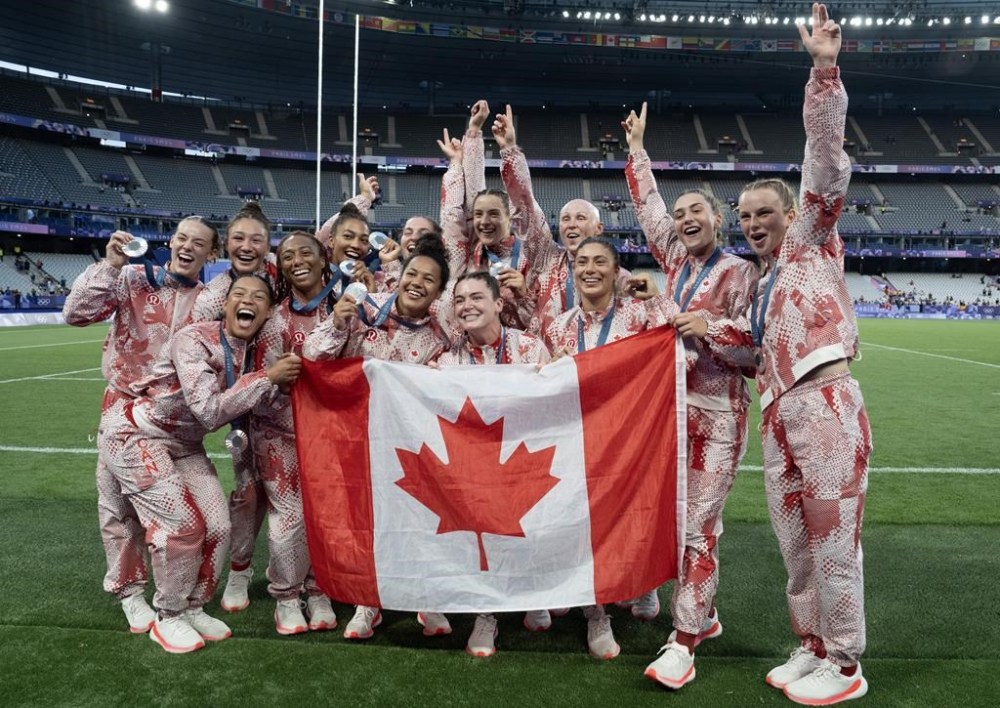 The women's rugby team poses for a team photo after winning the silver medal in the women's rugby sevens final action at the Summer Olympics in Paris, Monday, July 29, 2024. THE CANADIAN PRESS/Adrian Wyld