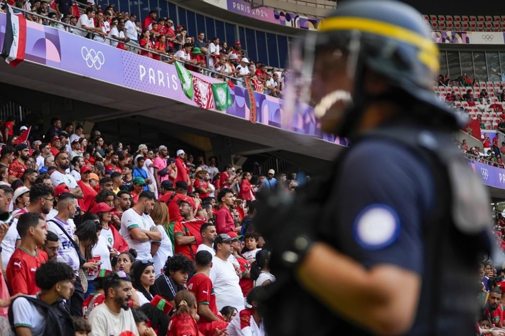 A security official stands guard near the pitch during a men's Group B soccer match between Morocco and Iraq at Nice Stadium at the 2024 Summer Olympics, Tuesday, July 30, 2024, in Nice, France. Morocco won 3-0. (AP Photo/Julio Cortez)