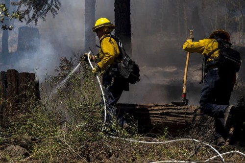 Firefighters put out hot spots from the Park Fire along Highway 32 near Forest Ranch, Calif., Tuesday, July 30, 2024. (AP Photo/Nic Coury)