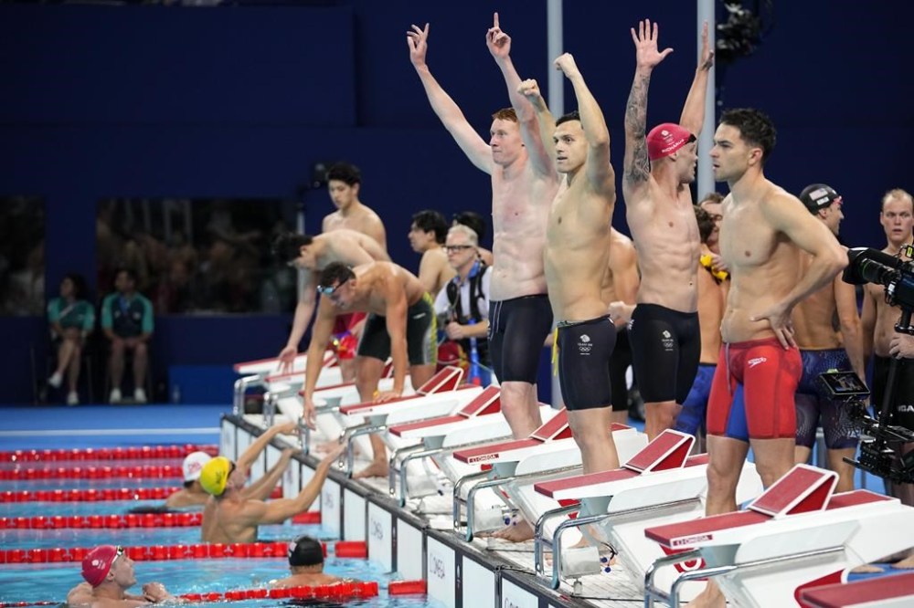 Britain's men's 4x200-meter freestyle relay team celebrate after winning the gold medal at the 2024 Summer Olympics, Tuesday, July 30, 2024, in Nanterre, France. (AP Photo/Petr David Josek)