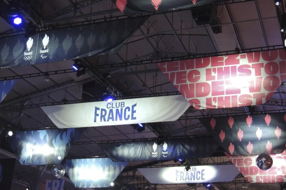 Banners the color of the French flag hang on the ceiling of the Club France, an Olympic fan zone, in northern Paris, France, Tuesday, July 30, 2024. (AP Photo/Tom Nouvian)