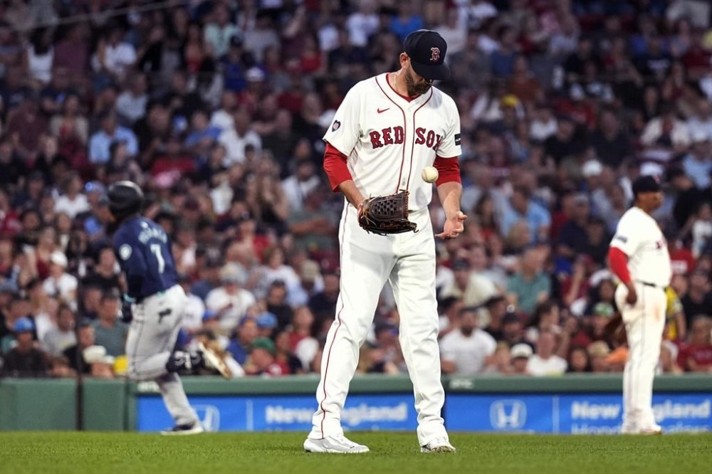 Boston Red Sox pitcher James Paxton looks down at a fresh baseball as Seattle Mariners' Jorge Polanco (7) rounds the bases on his solo home run during the fourth inning of a baseball game, Tuesday, July 30, 2024, in Boston. (AP Photo/Charles Krupa)