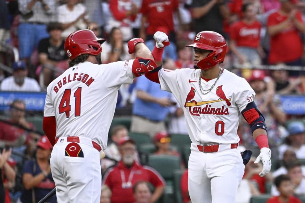 St. Louis Cardinals' Masyn Winn (0), right, is congratulated by teammate Alec Burleson after hitting a solo home run in the first inning of a baseball game against the Texas Rangers, Tuesday, July 30, 2024, in St. Louis. (AP Photo/Joe Puetz)