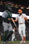 Oakland Athletics catcher Shea Langeliers, left, walks to the dugout after San Francisco Giants' Tyler Fitzgerald, right, struck out to end the eighth inning of a baseball game Tuesday, July 30, 2024, in San Francisco. (AP Photo/Godofredo A. Vásquez)