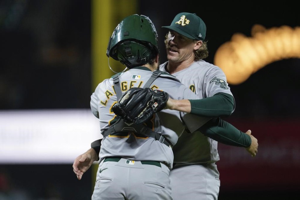 Oakland Athletics pitcher Tyler Ferguson, right, hugs catcher Shea Langeliers after the team's victory over the San Francisco Giants during a baseball game Tuesday, July 30, 2024, in San Francisco. (AP Photo/Godofredo A. Vásquez)