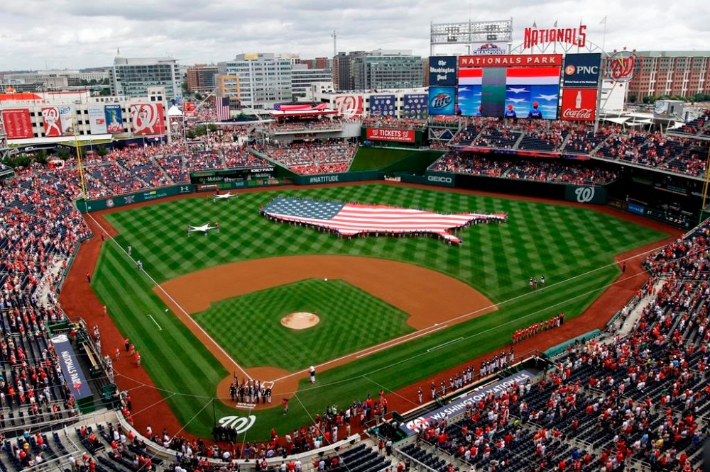 FILE - This July 4, 2013, file photo shows a U.S. flag, in the shape of the country, in the outfield before a baseball game between the Washington Nationals and the Milwaukee Brewers at Nationals Park in Washington. The attorney general for Washington, D.C. has sued StubHub, accusing the ticket resale platform of advertising deceptively low prices and then ramping up prices with extra fees. Attorney General Brian Schwalb said Wednesday the practice known as drip pricing violates consumer protection laws in the nation’s capital. The lawsuit says StubHub has sold nearly 5 million tickets in Washington since implementing the practice in 2015 and reaped about $118 million in fees. (AP Photo/Mark Tenally, File)