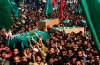 FILE - Thousands of Palestinian mourners carry the coffin of Hamas spiritual leader Sheik Ahmed Yassin, left, during his funeral in Gaza City, on March 22, 2004. (AP Photo/Khalil Hamra, File)