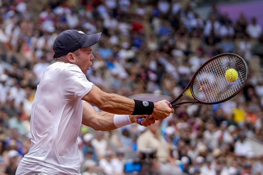 Germany's Dominik Koepfer returns the ball against Serbia's Novak Djokovic during the men's single tennis competition at the Roland Garros stadium, at the 2024 Summer Olympics, Wednesday, July 31, 2024, in Paris, France. (AP Photo/Manu Fernandez)