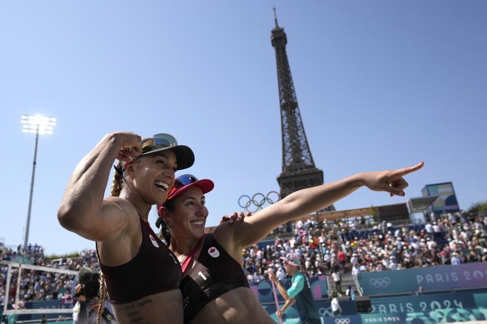 Canada's Brandie Wilkerson, left, and Canada's Melissa Humana-Paredes celebrate their victory over Paraguay in a beach volleyball match at the 2024 Summer Olympics, Monday, July 29, 2024, in Paris, France. (AP Photo/Robert F. Bukaty)