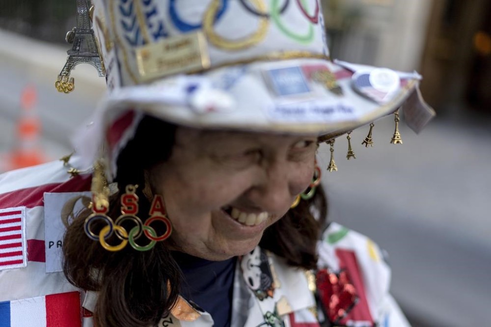 FILE - Miniature Eiffel Towers hang from the hat of Vivianne Robinson, of Los Angeles, as she walks through Paris ahead at the 2024 Summer Olympics, Saturday, July 20, 2024. The Olympics superfan has attended seven Games over the span of 40 years. (AP Photo/David Goldman, File)