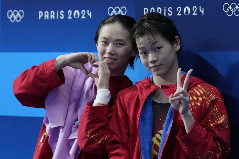 China's Chen Yuxi and Quan Hongchan celebrate after winning the gold medal in the women's synchronised 10m platform diving final at the 2024 Summer Olympics, Wednesday, July 31, 2024, in Saint-Denis, France. (AP Photo/Jin Lee Man)
