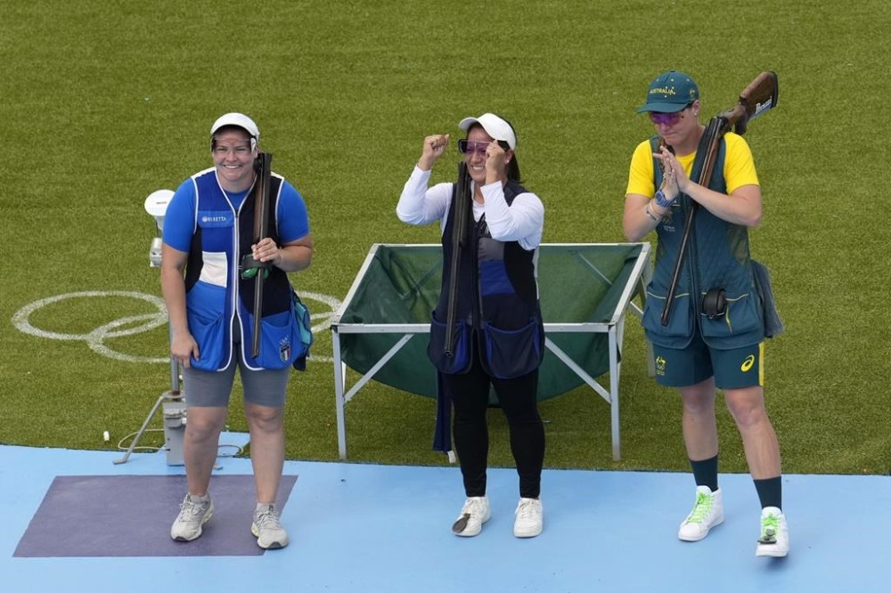 Guatemala's Adriana Oliva Ruano, center, Italy's Silvana Maria Stanco, left, and Australia's Penny Smith celebrate after winning the first, second and third positions in the Trap women's final at the 2024 Summer Olympics, Wednesday, July 31, 2024, in Chateauroux, France. (AP Photo/Manish Swarup)