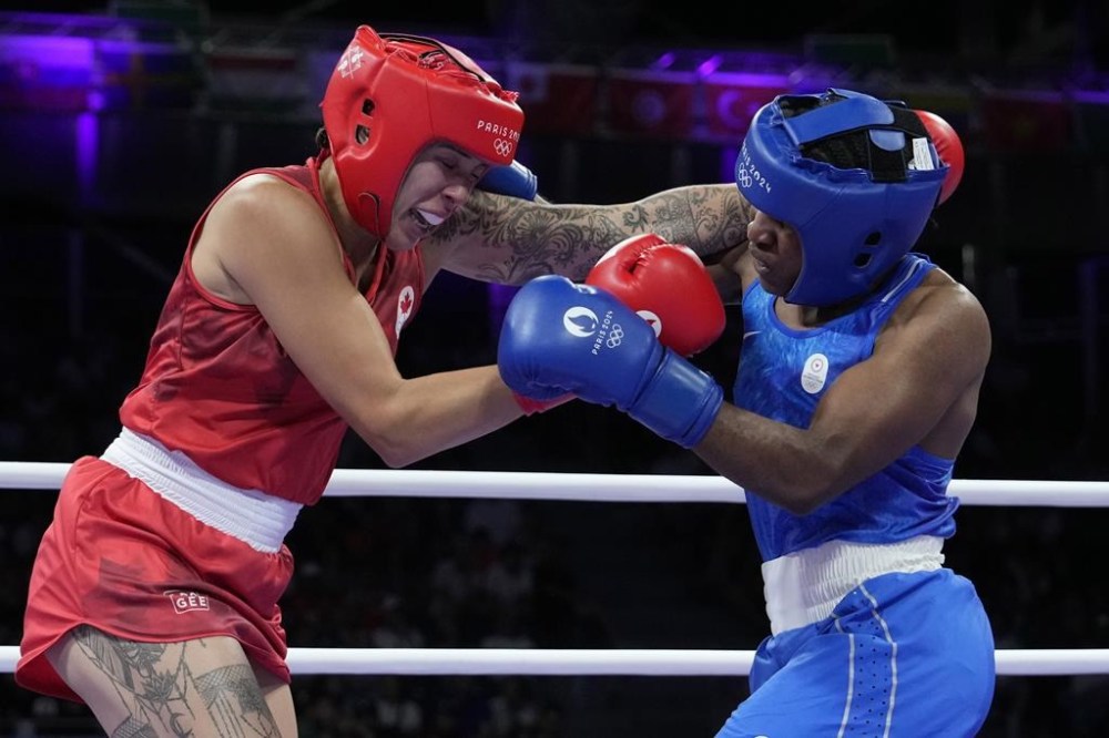 Canada's Tammara Thibeault, left, fights Refugee Olympic Team's Cindy Ngamba in their women's 75 kg preliminary boxing match at the 2024 Summer Olympics, Wednesday, July 31, 2024, in Paris, France. THE CANADIAN PRESS/AP/Ariana Cubillos