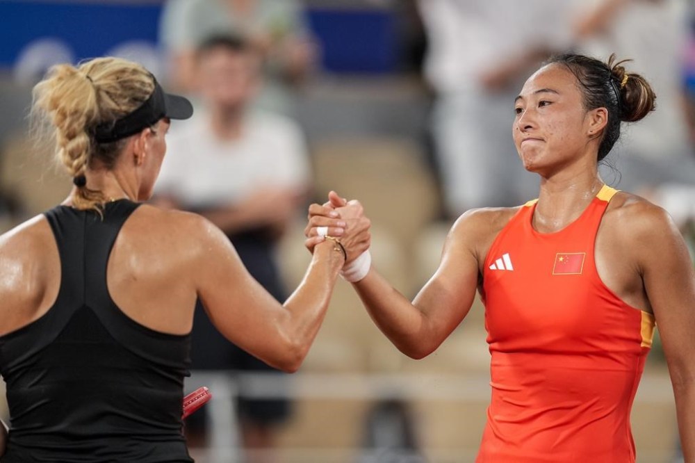 Qinwen Zheng of China, right, shakes hands after winning with Angelique Kerber of Germany during their women's single quarter-final tennis competition at the Roland Garros stadium, at the 2024 Summer Olympics, Wednesday, July 31, 2024, in Paris, France. (AP Photo/Manu Fernandez)