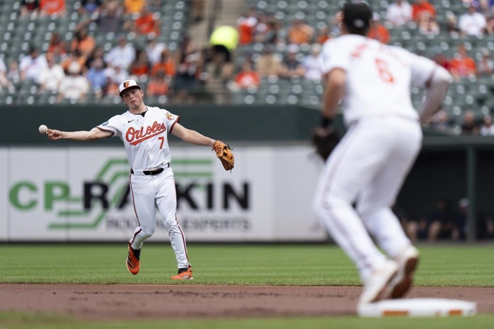 Baltimore Orioles second baseman Jackson Holliday (7) throws to first baseman Ryan Mountcastle (6) for an out on a ground ball hit by Toronto Blue Jays' Spencer Horwitz during the first inning of a baseball game, Wednesday, July 31, 2024, in Baltimore. (AP Photo/Stephanie Scarbrough)