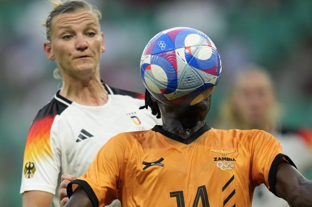 Zambia's Prisca Chilufya is challenged from behind by Germany's Alexandra Popp during the women's Group B soccer match between Zambia and Germany, at Geoffroy-Guichard Stadium, during the 2024 Summer Olympics, Wednesday, July 31, 2024, in Saint-Etienne, France. (AP Photo/Silvia Izquierdo)