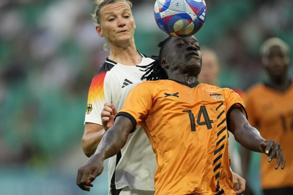 Zambia's Prisca Chilufya is challenged from behind by Germany's Alexandra Popp during the women's Group B soccer match between Zambia and Germany, at Geoffroy-Guichard Stadium, during the 2024 Summer Olympics, Wednesday, July 31, 2024, in Saint-Etienne, France. (AP Photo/Silvia Izquierdo)