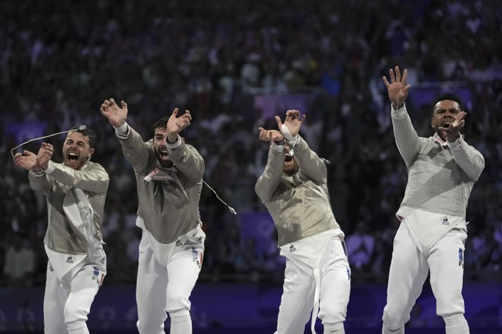 From left: France's Sebastien Patrice, France's Maxime Pianfetti, France's Jean-Philippe Patrice and France's Bolade Apithy celebrate after winning the men's team sabre bronze final match against Iran during the 2024 Summer Olympics at the Grand Palais, Wednesday, July 31, 2024, in Paris, France. (AP Photo/Thibault Camus)