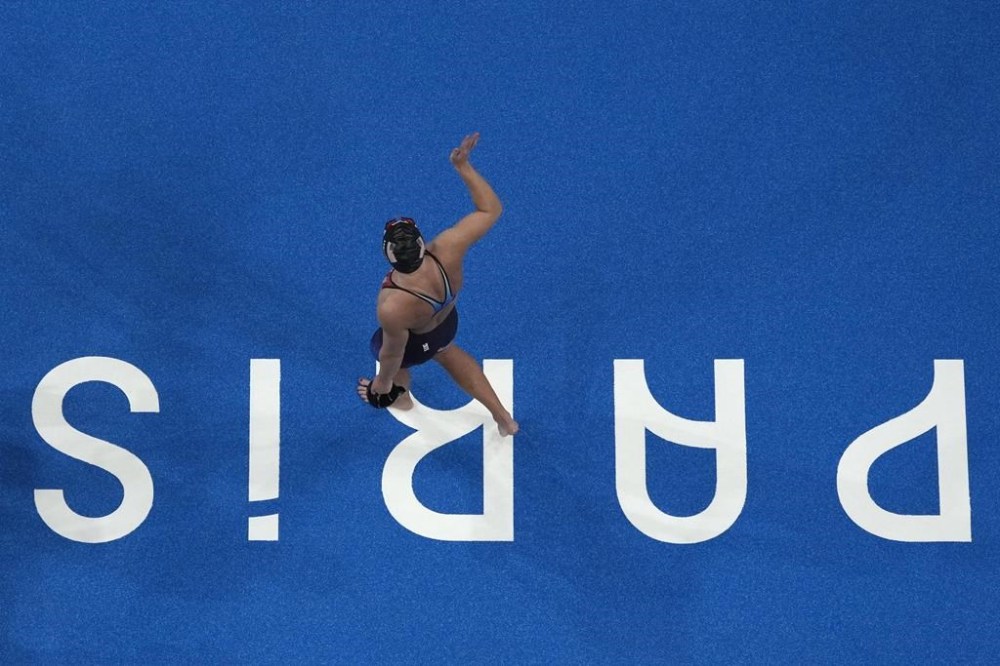 Katie Ledecky, of the United States, waves to the crowd after setting a new Olympic record winning the women's 1500-meter freestyle final at the 2024 Summer Olympics, Wednesday, July 31, 2024, in Nanterre, France. (AP Photo/David J. Phillip)