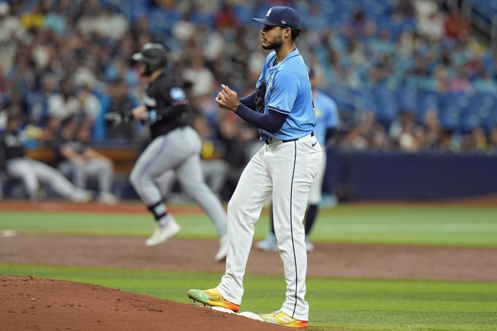 Tampa Bay Rays starting pitcher Taj Bradley rubs a new basseball as Miami Marlins' Jake Burger (36) runs the bases following his two-run home run during the third inning of a baseball game Wednesday, July 31, 2024, in St. Petersburg, Fla. (AP Photo/Christopher O'Meara)