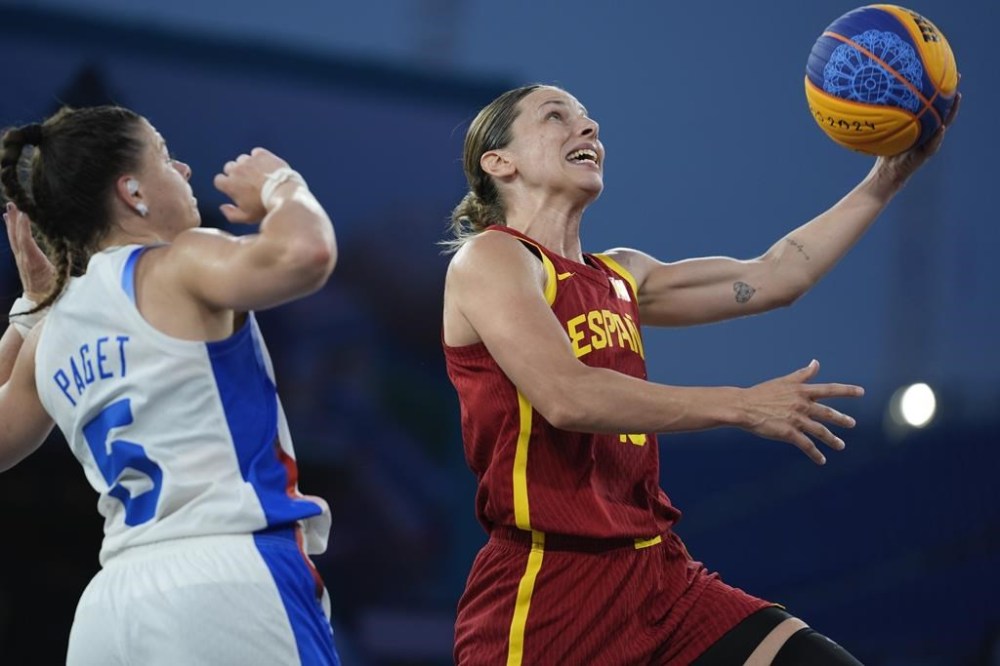 Spain's Sandra Ygueravide goes to the basket defended by France's Marie Eve Paget in the women's 3x3 basketball pool round match between France and Spain at the 2024 Summer Olympics, Wednesday, July 31, 2024, in Paris, France. (AP Photo/Rebecca Blackwell)