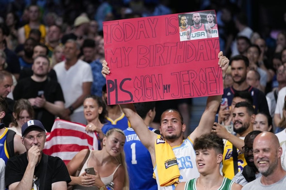 United States fans cheer before the start a men's basketball gamebetween the United States South Sudan at the 2024 Summer Olympics, Wednesday, July 31, 2024, in Villeneuve-d'Ascq, France. (AP Photo/Mark J. Terrill)