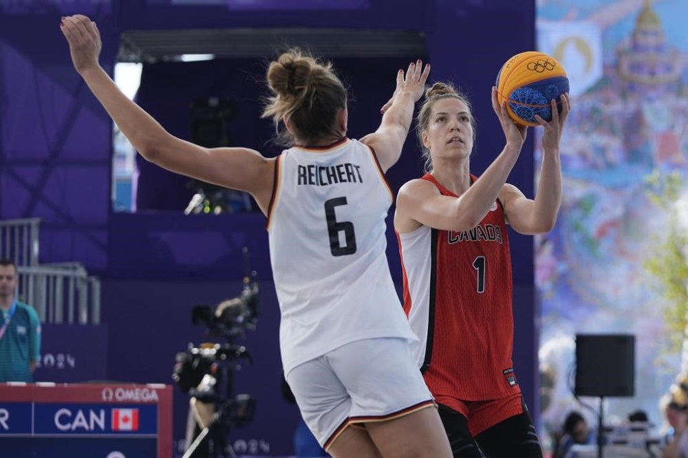 Canada's Michelle Plouffe (1) shoots over Germany's Marie Reichert (6) in the women's 3x3 basketball pool round match during the 2024 Summer Olympics, Thursday, Aug. 1, 2024, in Paris, France. Germany won 19-15. THE CANADIAN PRESS/AP/Frank Franklin II